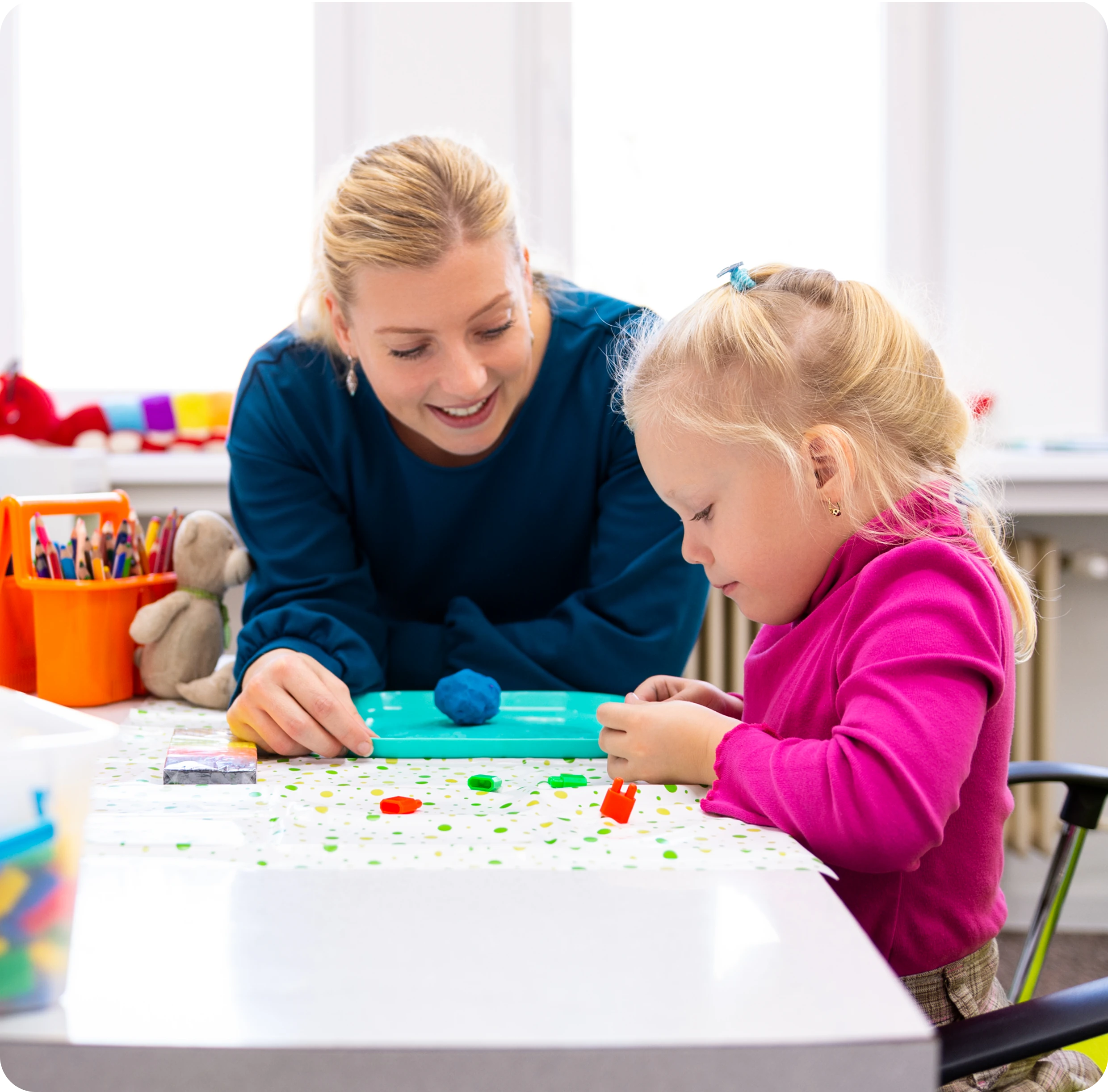 Teacher and child engaging in classroom activity.